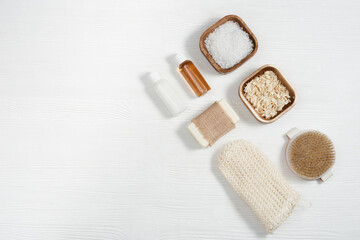 Flat lay composition with bath accessories with small bottles with gel and shampoo, soap, sea salt,...