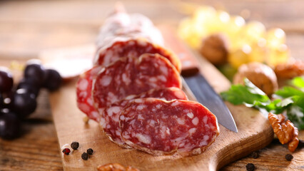 close up on french salami on wooden board