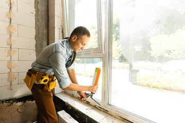 Construction worker installing window in house