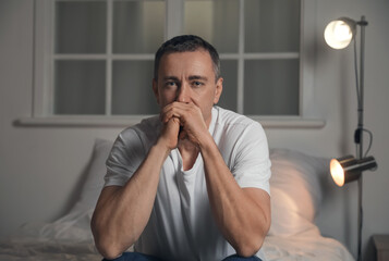 Depressed mature man in bedroom