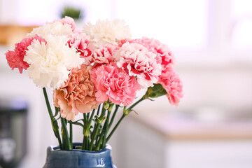 Vase with beautiful carnations in kitchen