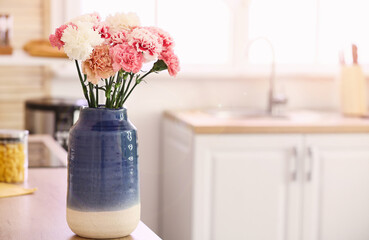 Vase with beautiful carnations in kitchen