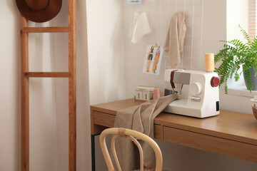 Table with sewing machine and cloth in tailor's workshop