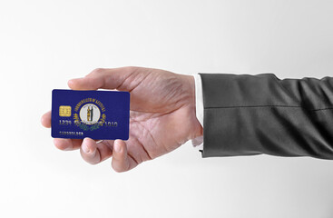 Bank credit plastic card with flag of USA state Kentucky holding man in elegant suit