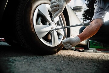 Hand of a mechanic changing wheels and tires while working in the car repair center
