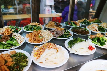 There are a variety of Chinese dishes in the glass showcase