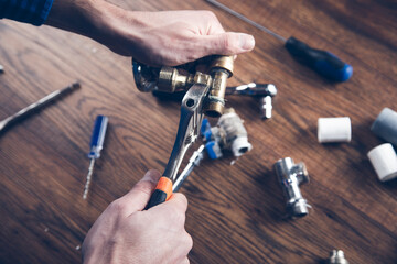 Plumber screws brass fitting into the valve with a plumbing wrench