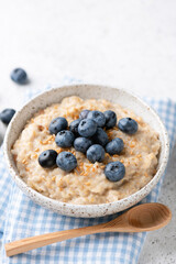 Oatmeal bowl with blueberries and flax seeds. Scottish oats, vegan breakfast