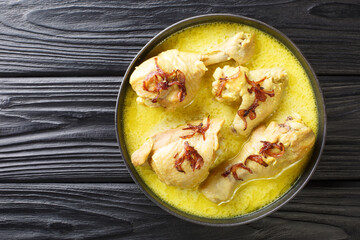 Indonesian chicken stew in coconut milk with spices close-up in a bowl on the table. horizontal top view from above