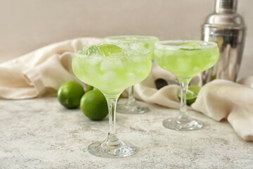 Glasses of tasty daiquiri cocktail on light background