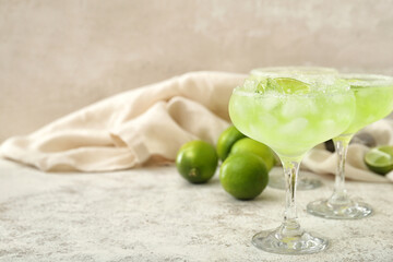 Glasses of tasty daiquiri cocktail on light background