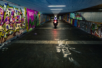 Biker in Tunelsystem mit Gaffiti Kunst an den Wänden
