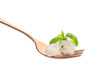 Fork with delicious gnocchi, creamy sauce and basil leaves on white background
