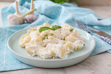Plate of delicious gnocchi with creamy sauce on table