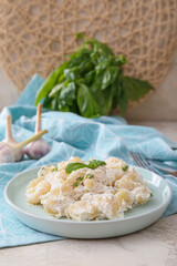 Plate of delicious gnocchi with creamy sauce on table