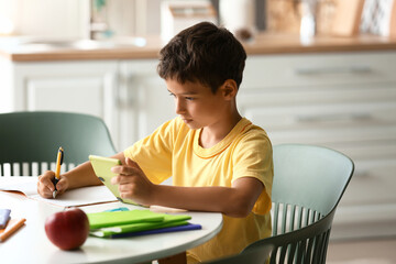 Little boy doing homework in room