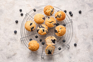 Grid with tasty blueberry muffins on light background