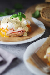 Egg benedict sandwiches - muffin with poached egg, ham and hollandaise sauce