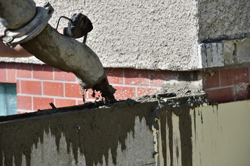 Detail of a concrete pump from which concrete is poured into walls on the construction site