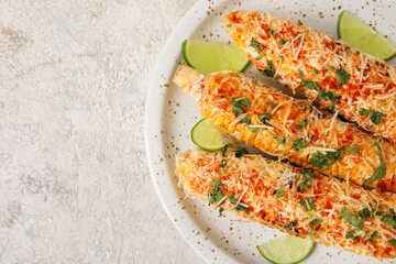 Plate with tasty Elote Mexican Street Corn on grunge background, closeup