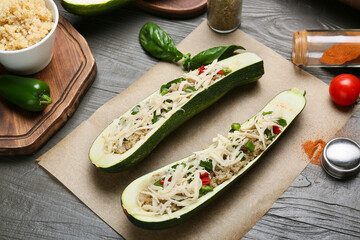 Composition with quinoa stuffed zucchini boats on wooden background