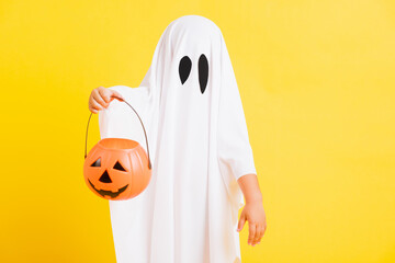 Funny Halloween Kid Concept, little cute child with white dressed costume halloween ghost scary he...