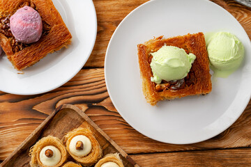 Turkish dessert kunefe served with ice cream on wooden background