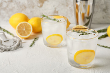 Glasses of cold gin tonic on light background