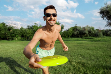 Young man playing frisbee in park