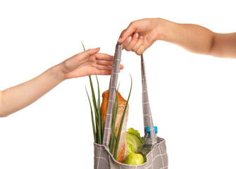 Woman receiving Eco bag with products from another person on white background, closeup
