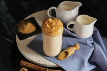 Glass of tasty dalgona hojicha latte on dark background
