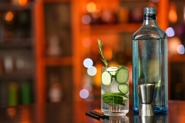 Glass of cold cucumber gin and tonic on table in bar