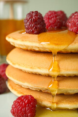 Tasty pancakes with berries and honey on table, closeup