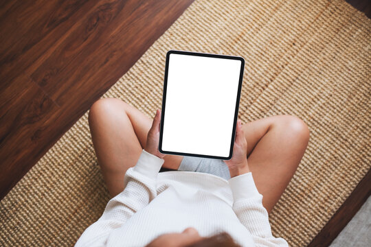 Top vie mockup image of a woman holding digital tablet with blank desktop screen at home