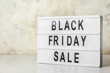 Board with text BLACK FRIDAY SALE on light background