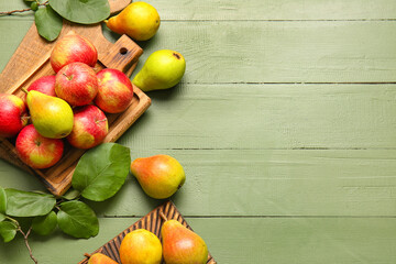 Boards with ripe pears and apples on color wooden background