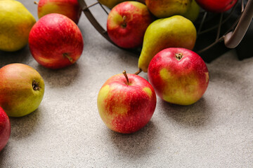 Basket with ripe pears and apples on white background
