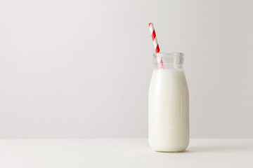 A glass of milk with drinking straw on white background.