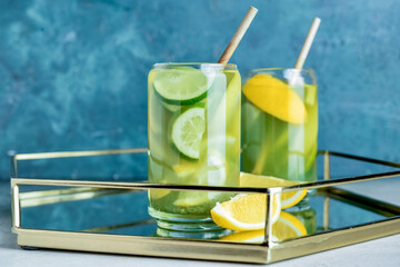 Tray with glasses of tasty lemonade on color background