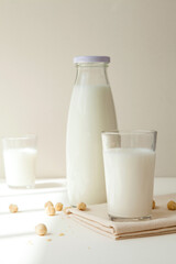 milk in glass bottle and cup on table.