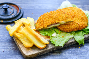 
 Crispy  deep fried home made     chicken Cordon bleu with cheese   and ham  and french fries on...