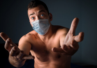 A naked man in a medical mask. One on self-isolation. The coronavirus pandemic.