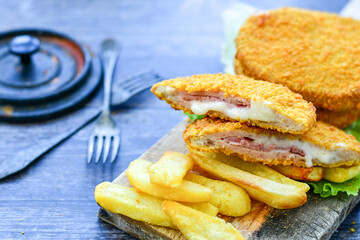 
 Crispy  deep fried home made     chicken Cordon bleu with cheese   and ham  and french fries on...