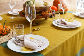 Beautiful table setting with fallen leaves in room