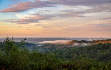 Low clouds and dramatic colours in the sky over the Devils Punch Bowl during sunset on the Surrey Hills near Hindhead south east England