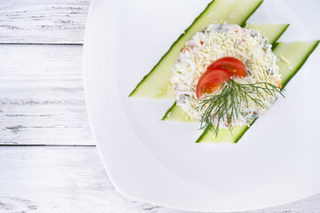 Olivier salad in ceramic white plate on white background horizontal