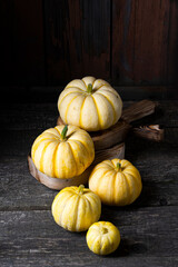 small yellow pumpkins on dark wooden background