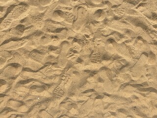 Lots of footstep marks in beach sand.