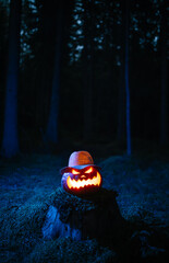 Pumpkin lantern burning in the dark forest the traditional Halloween holiday. Concept background holiday of horror.