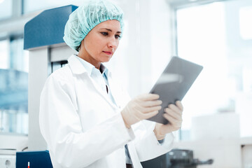Female pharmacist using digital tablet at medical store